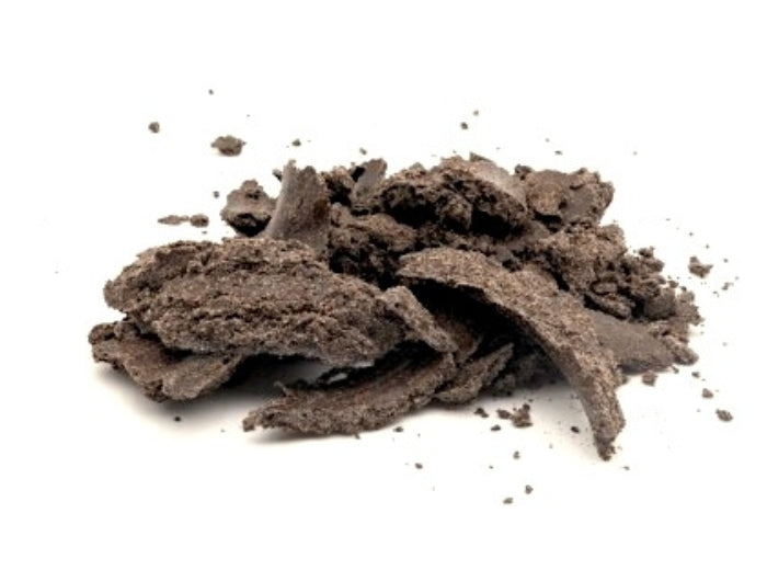 Drachenkopf Presskuchen Flakes auf weißem Hintergrund