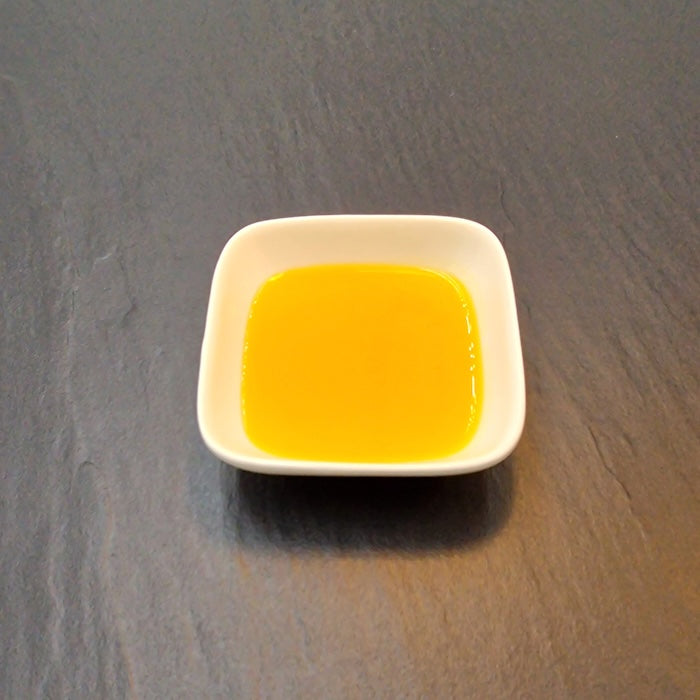 Goldgelbes Bio-Leinöl in einer weißen Schale.