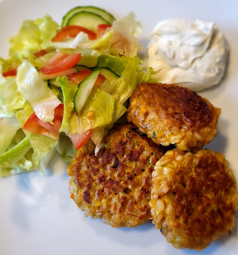 Bayrische Reispflanzerl mit Dip und Salat auf weißem Teller