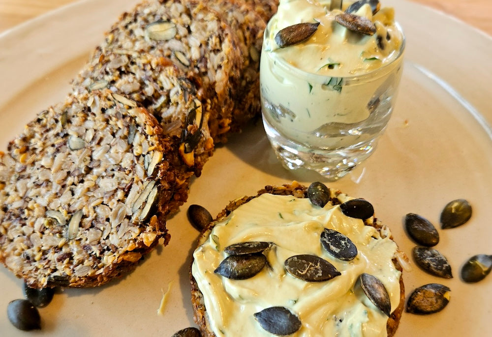 Saatenbrot aufgeschnitten, garniert mit Butter und Kürbiskernen